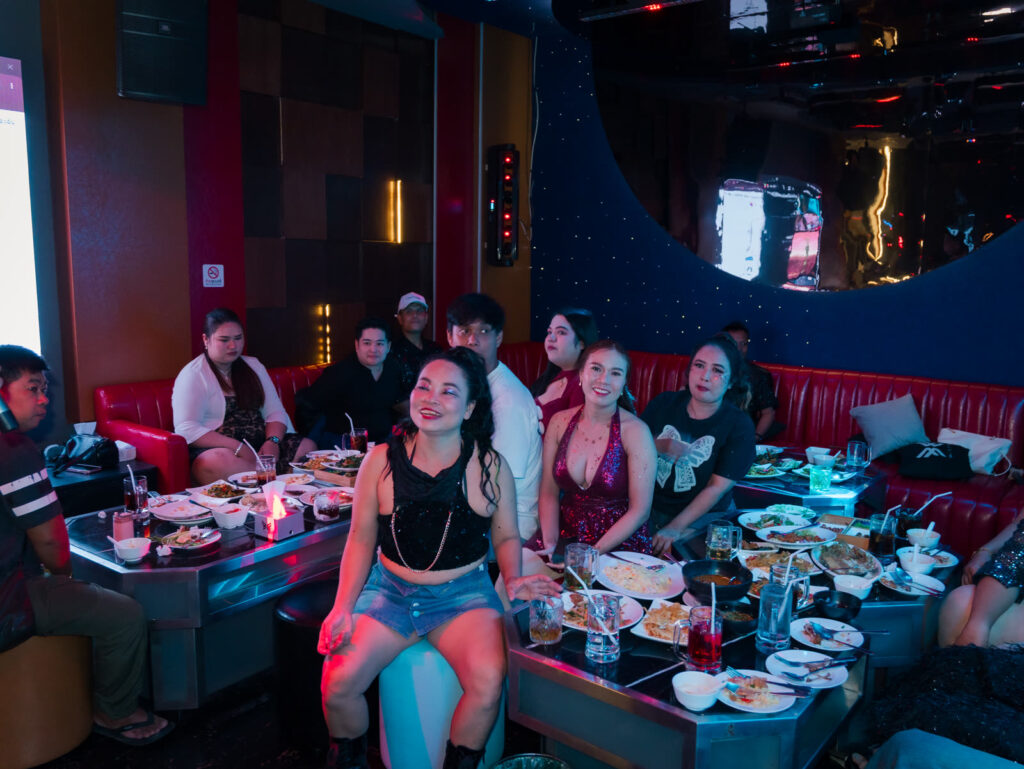 Glam Habitat staff gathered around a table full of food, laughing together