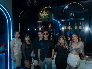 Glam Habitat staff dressed in glam evening wear posing at the neon-lit KTV bar