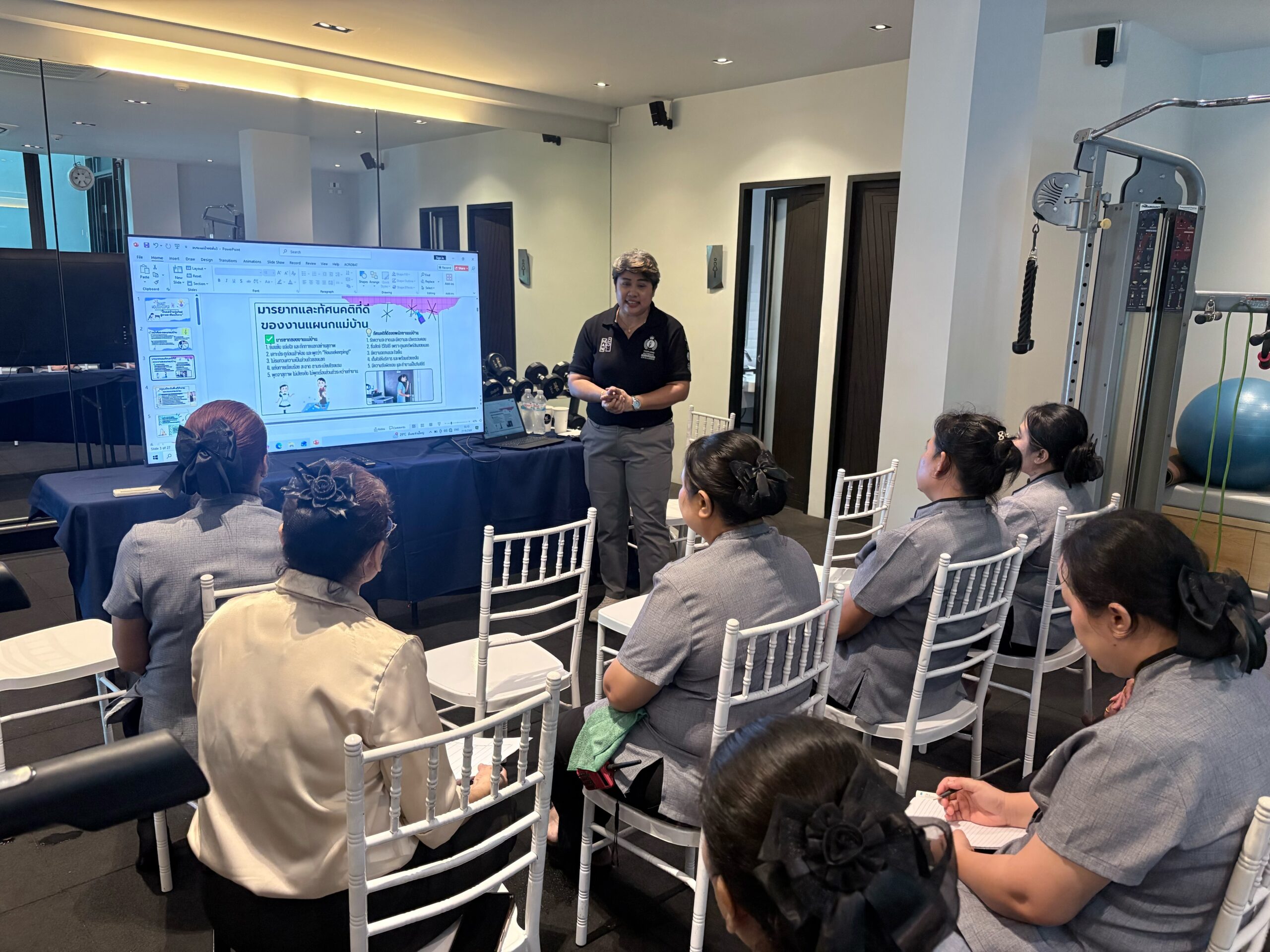 Trainer presenting a slide on housekeeping etiquette and guest interaction manners