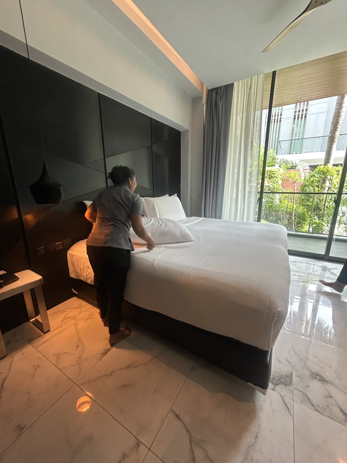 A freshly made hotel bed with folded towels, the result of the team's hands-on practice