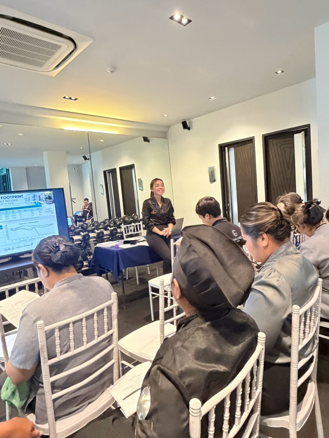 A Glam Habitat trainer presents the hotel's monthly Carbon Footprint record to kitchen and housekeeping staff during Green Awareness training
