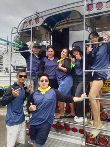 Glam Habitat staff in matching jerseys posing on the back of the decorated party truck at the start of Outing 2026