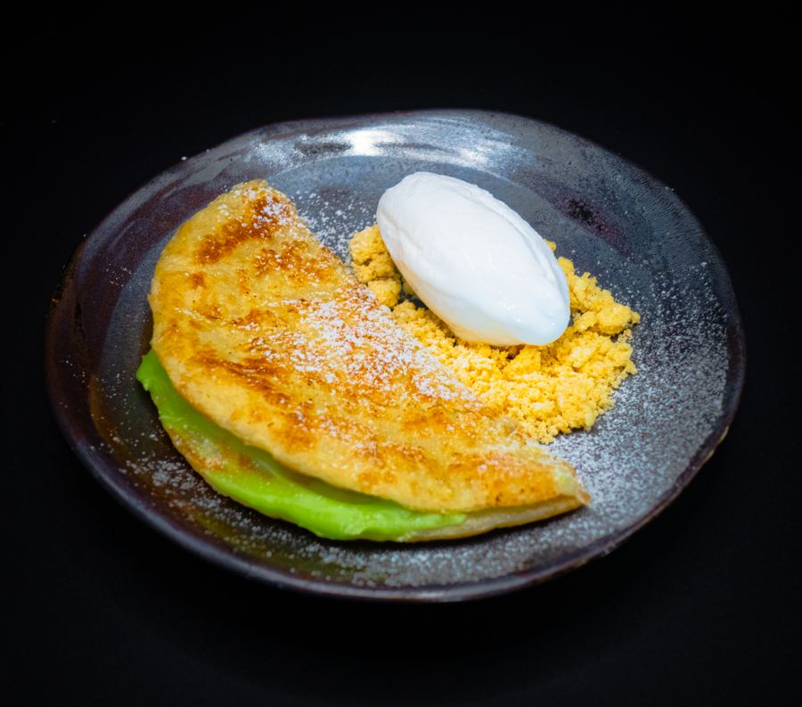 Golden crêpe-style dessert with a scoop of ice cream and crumble