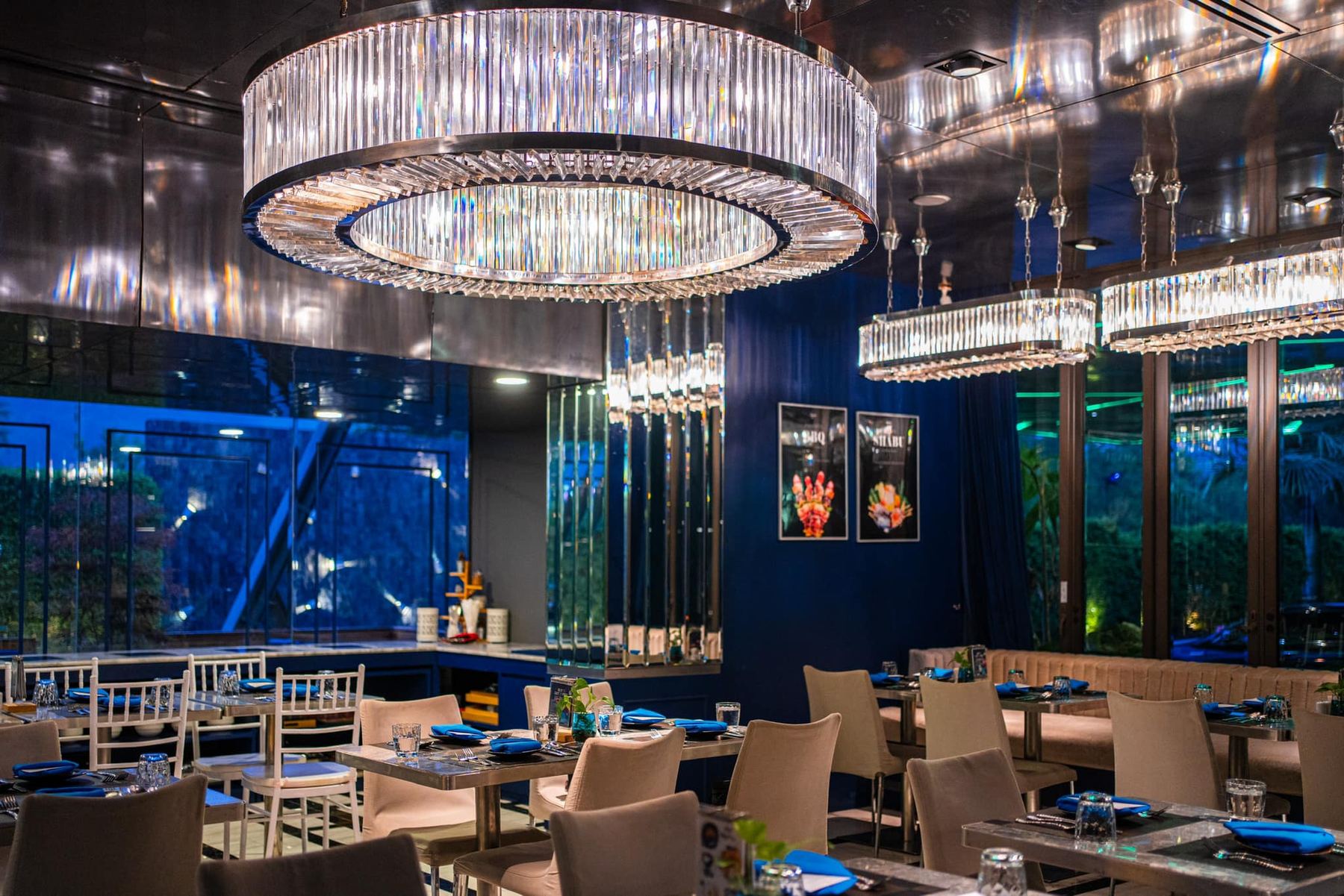 Interior of Sapphire at Glam Habitat Hotel with chandeliers and windows onto greenery
