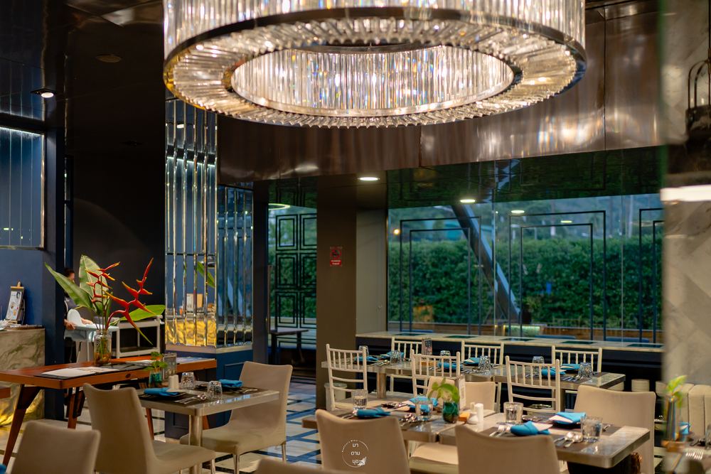 Tables at Sapphire beside floor-to-ceiling windows looking out to tropical greenery