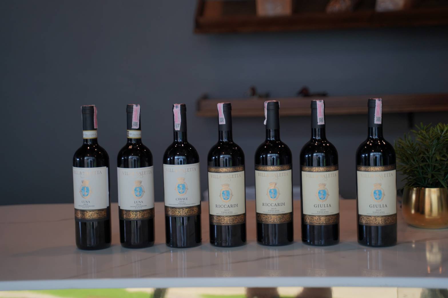 A line-up of Villa Saletta Tuscan wines including Luna, Chiave, Riccardi and Giulia on a marble counter