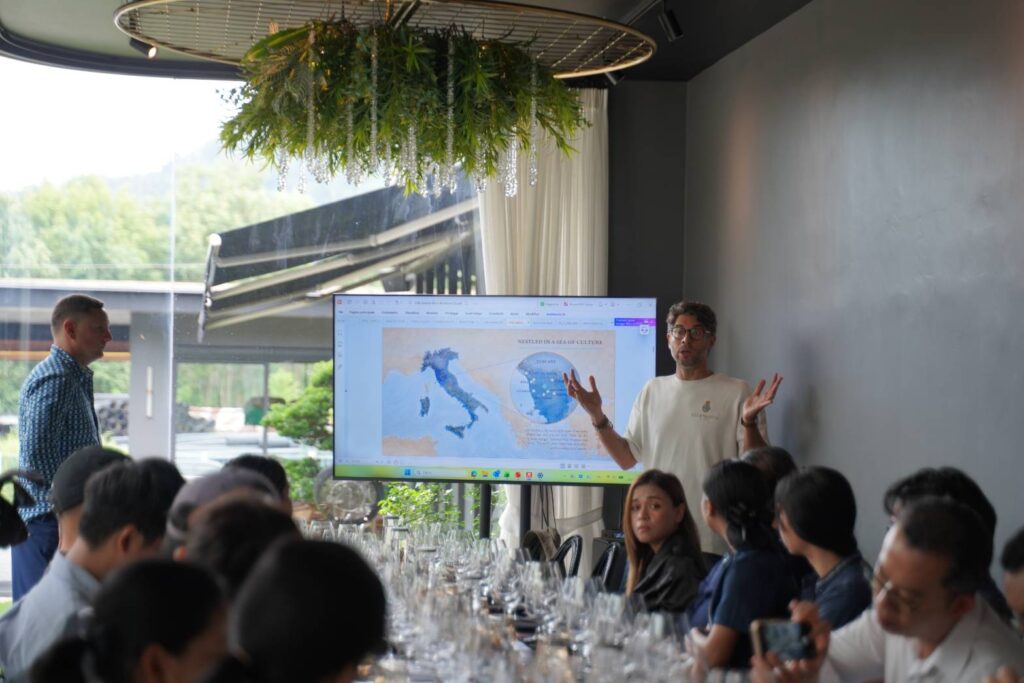 A Villa Saletta presenter explaining the estate's location in Tuscany on a map of Italy during the wine masterclass