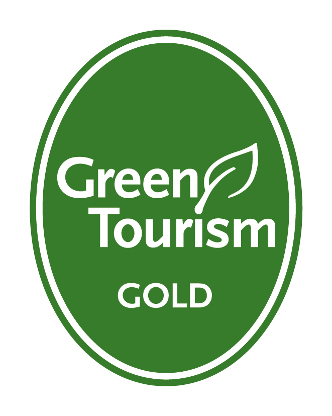 Green Tourism Gold Award logo, a white leaf and lettering on a green oval