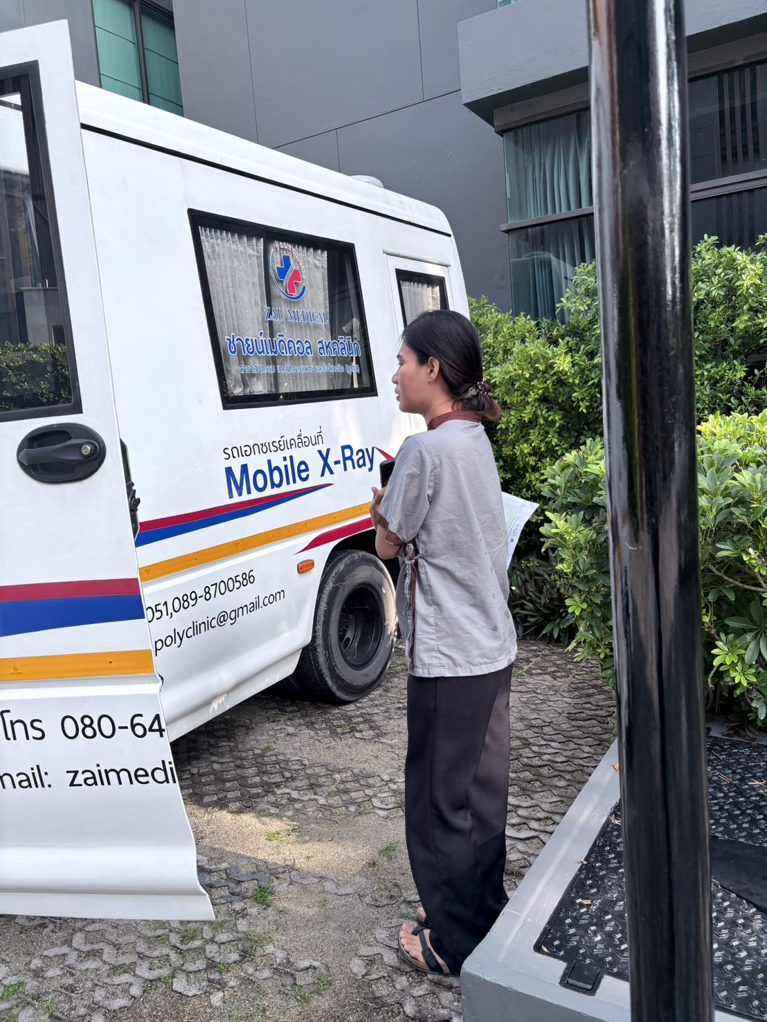 A Glam Habitat team member stepping up to the mobile chest X-ray van parked at the hotel