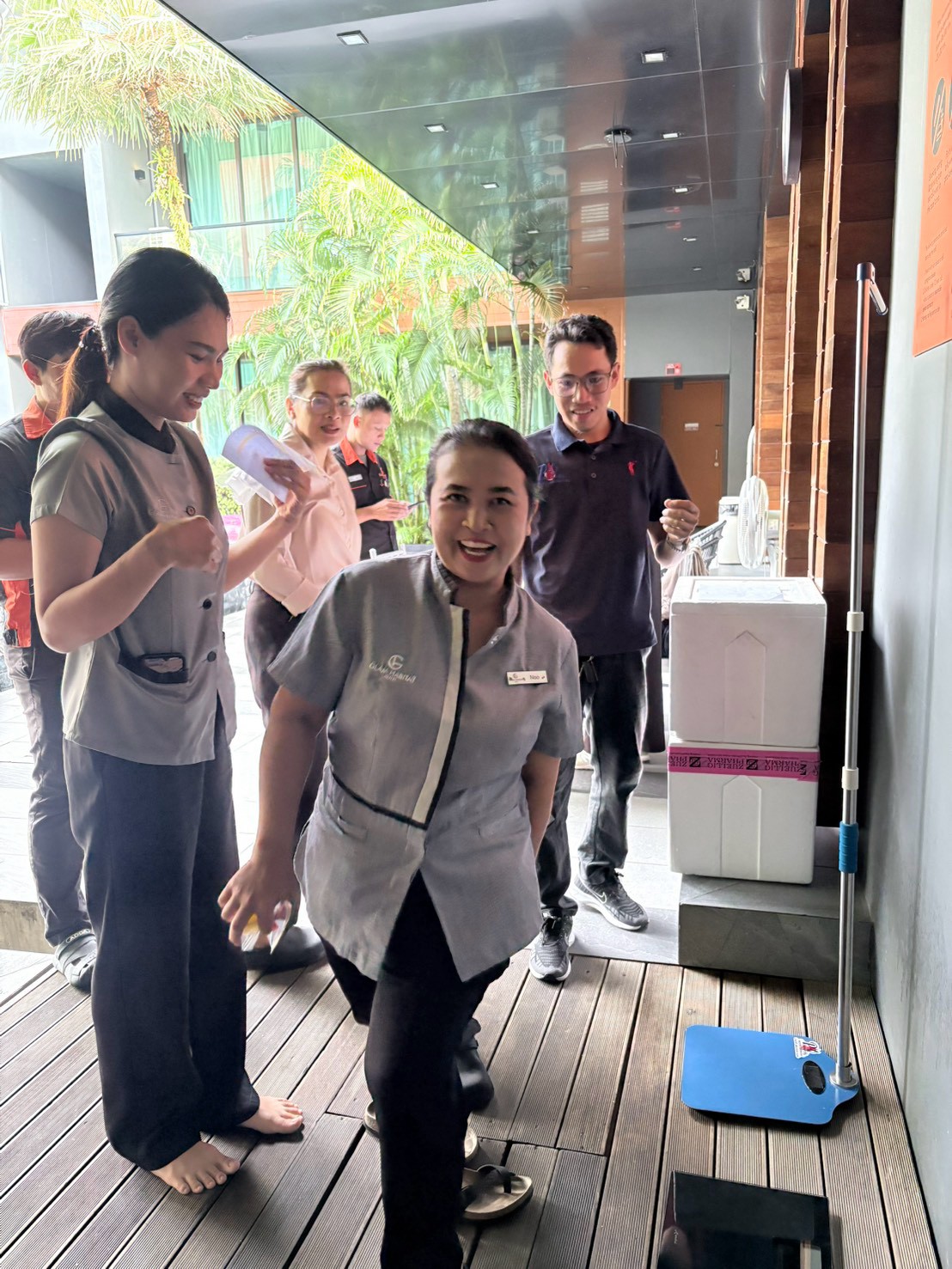 Glam Habitat team members laughing together at the height and weight station on the hotel terrace