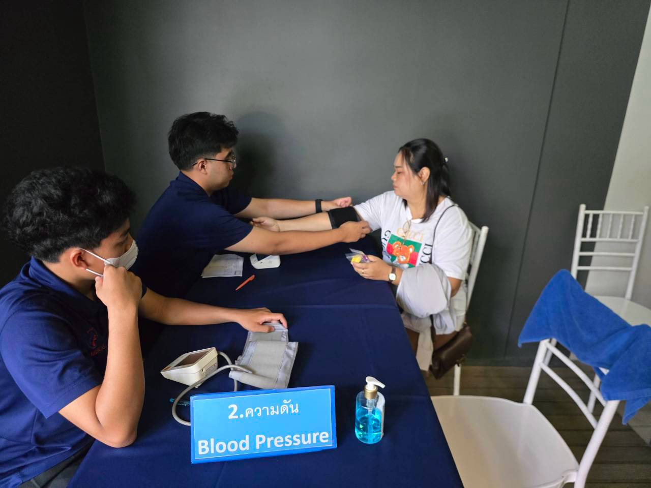 A Phuket International Hospital staff member measuring a team member's blood pressure at the health check station