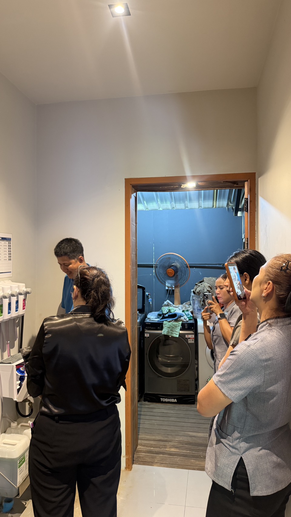 Glam Habitat housekeeping team members filming the ECOLAB chemical station demonstration in the housekeeping chemical room