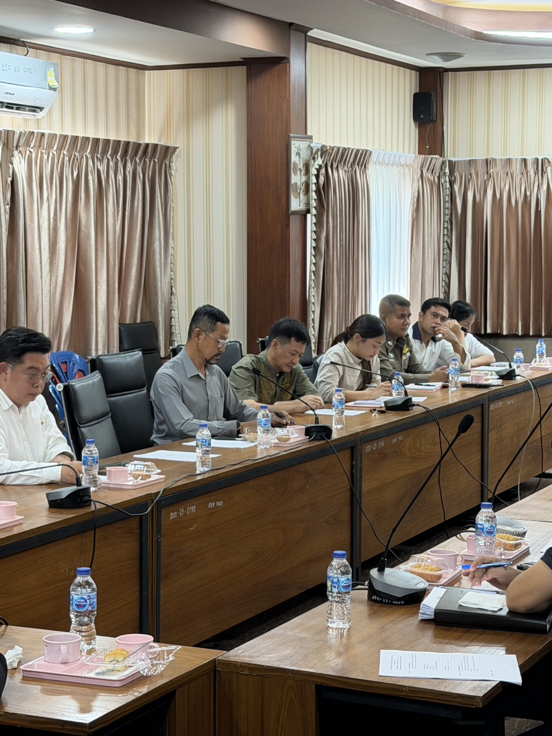 Community leaders, local officials and a police officer reviewing documents at the Kamala SAO meeting