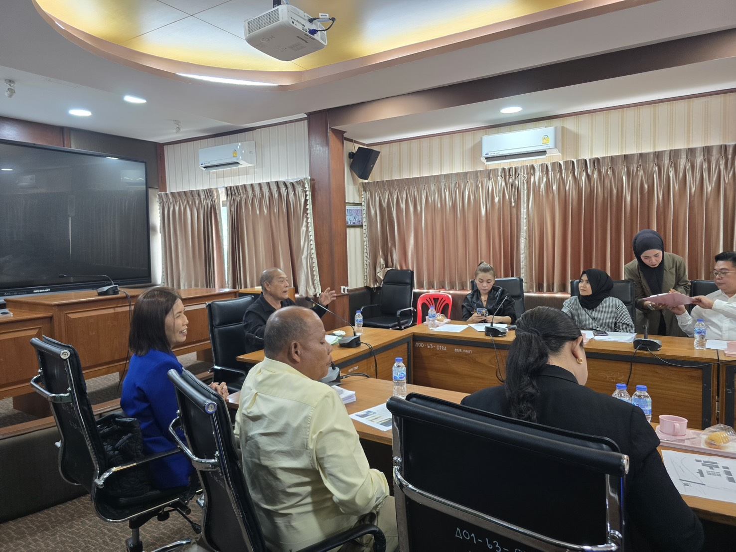 Kamala SAO officials and local participants in discussion as meeting documents are handed around